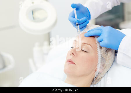 Die moderne Frau in Anti-aging-Injektion in die Stirn Stockfoto