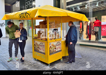 Straßenhändler mit Sesam Brot Ringe an ihrem Stall entlang der Ermou Straße im Zentrum von Athen, Griechenland Stockfoto