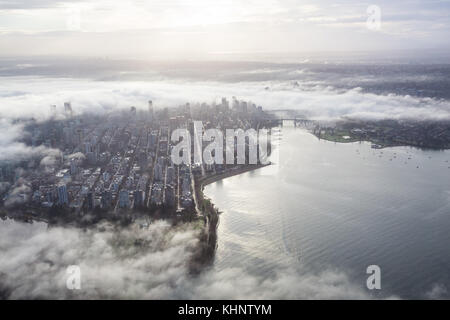 Luftbild der Innenstadt von Vancouver, British Columbia, Kanada, in den Wolken bedeckt. Während einer nebligen Winter Sonnenaufgang genommen. Stockfoto