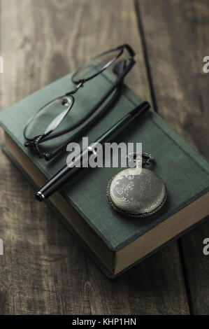 Antike Taschenuhr, Brille und Buch, Jahrgang noch Leben Stockfoto