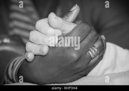 Hand der Krankenschwester, die im Besitz einer älteren Frau. Konzept der helfende Hände, der Altenpflege. Bild in Schwarz und Weiß Stockfoto