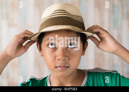 Jungen asiatischen Boy Hut trägt und glücklich lächelnd. Kleidung Travel Concept Stockfoto