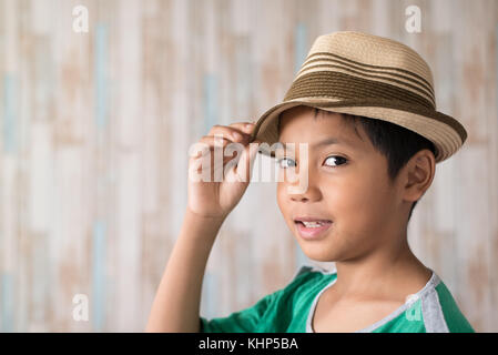 Jungen asiatischen Boy Hut trägt und glücklich lächelnd. Kleidung Travel Concept Stockfoto