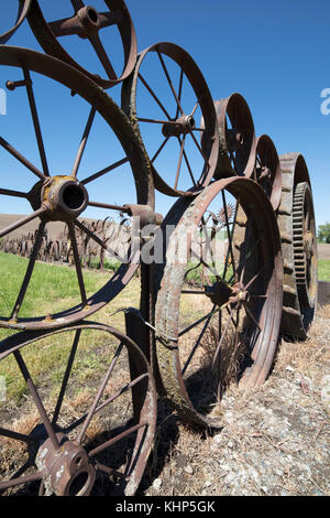 Alter Bauernhof Zaun von alten verrosteten Wagen & Räder des Schleppers an die Handwerker, die auf der dahmen Scheune ist auf der Palouse Scenic Byway in Uniontown, Washington, Stockfoto