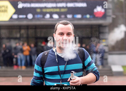 Junge, urbane Menschen rauchen vape vor unscharfen Menge von Menschen. vape & Expo an der Akko International Expo-Zentrum. Am 19. März 2017 in Kiew, Ukraine Stockfoto