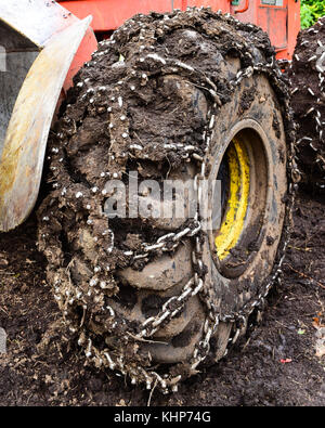 Nahaufnahme eines skidder Traktor Reifen mit Ketten mit Schlamm bedeckt. Stockfoto