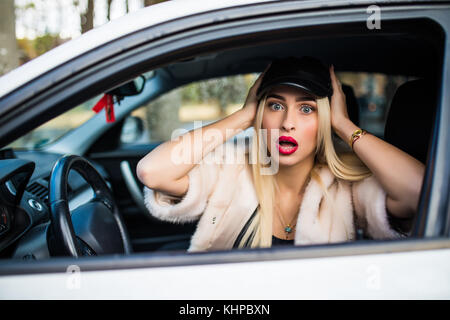 Abgelenkt Schreck Gesicht einer Frau fahren Auto, weit geöffneten Mund Augen holding Radseite Fenster anzeigen. negativen menschlichen Gesichtsausdruck emotion Reaktion. t Stockfoto