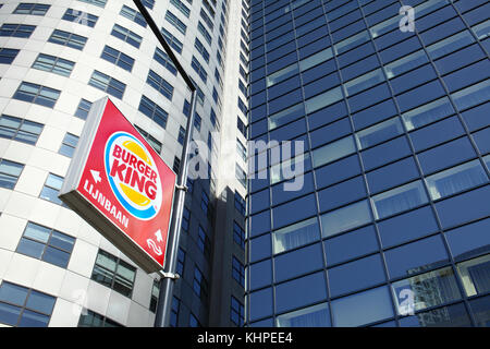 Ein fast food Zeichen unter High Rise office Blöcke auf Weena, Rotterdam, Niederlande. Stockfoto