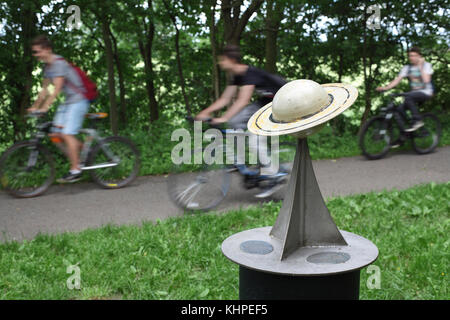 Radfahrer fahren an einem Modell des Planeten Saturn auf dem Radweg von York nach Selby vorbei, wo sich ein Modell des Sonnensystems im Maßstab 10,4 km befindet. Stockfoto