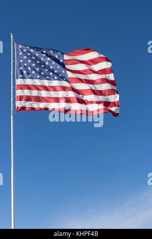 Eine rote, weiße und blaue amerikanische Flagge mit Sternen und Streifen in den Wind unfurled. Gegen den tiefblauen Himmel mit Cirrus Wolken fotografiert. Stockfoto