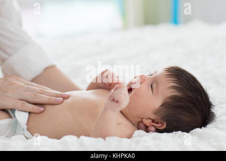 Masseur massieren den Bauch des Babys Stockfoto