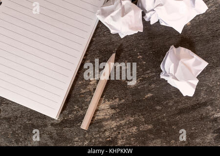 Notebook mit Stift und zerknittertes Papier auf Holztisch. Business Konzept. Stockfoto