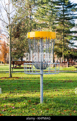 Spielen Korb mit Ketten für das Werfen fliegende Scheiben im Park mit Bäumen und Gras Stockfoto