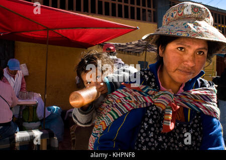 Eine Mutter trägt ihre Tochter in der Nähe des Chivay-Marktes, einer der kleinen Städte im Colca-Tal. Colca Canyon, Arequipa, Peru Stockfoto