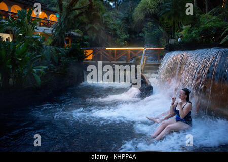 Heiße Quellen aus dem Arenel vocano an der Tabacón Grand Spa, Costa Rica. Besucher genießt eine der warmen Ströme, fließt durch Tabacon Hot Spring Stockfoto