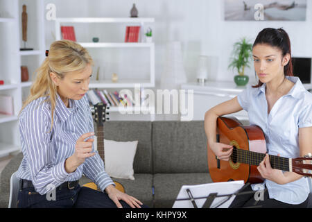 Fröhlicher junger jugendlich Musiker Gitarre spielen Stockfoto