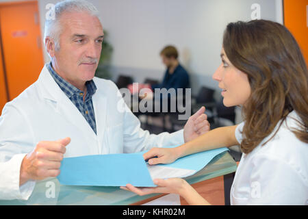 Arzt und der Rezeptionist Suchen in Dateien Stockfoto