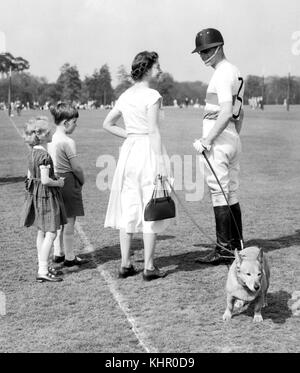 06/05/1956. Königin Elizabeth II. Hält einen der Royal Corgis, während sie mit dem Herzog von Edinburgh spricht, während er im Smith's Lawn, Windsor Great Park, Polo spielt. Das Königspaar feiert am 20. November seinen Platin-Hochzeitstag. Stockfoto