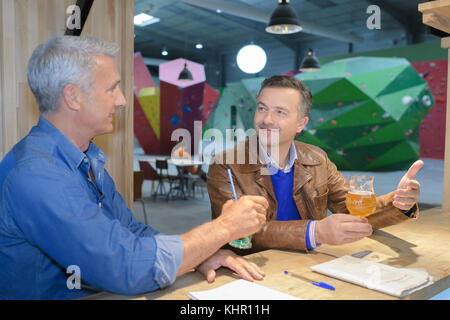 Zwei reife Menschen klettern Bar mit Bier sitzen Stockfoto