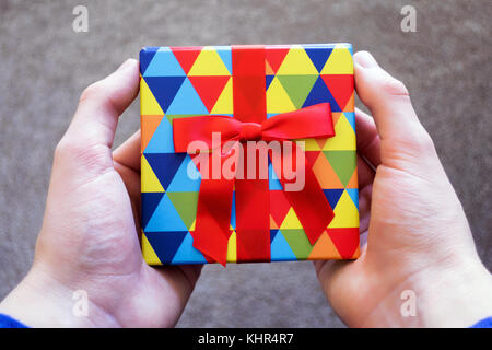 Ein Mann mit einer kleinen, bunten gift card Box aus. Stockfoto