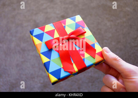 Ein Mann mit einer kleinen, bunten gift card Box aus. Stockfoto