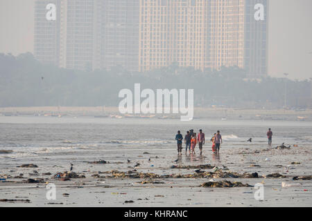 Menschen zu Fuß unter plastik Müll und Abwasser bei Ebbe am Strand, versova Mumbai Stockfoto