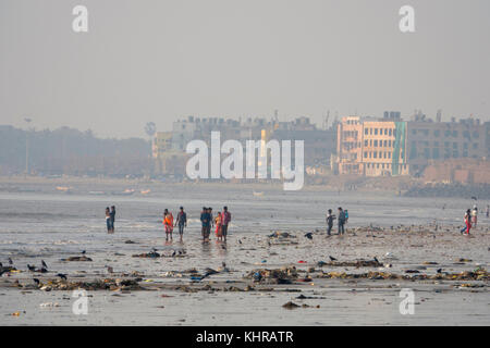 Menschen zu Fuß unter plastik Müll und Abwasser bei Ebbe am Strand, versova Mumbai Stockfoto