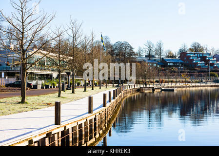 Vaxjo, Schweden - 13. November 2017: Dokumentation des Alltags und der Umwelt. Uferpromenade am See am sonnigen Herbstmorgen mit einer dünnen Schicht Rauschtier Stockfoto
