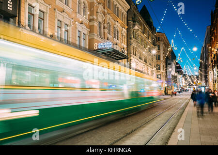 Helsinki, Finnland - 6. Dezember 2016: Straßenbahn fährt in motion blur von Stop auf aleksanterinkatu Straße in Kluuvi erhalten Bezirk in Abend Nacht Weihnachten x Stockfoto