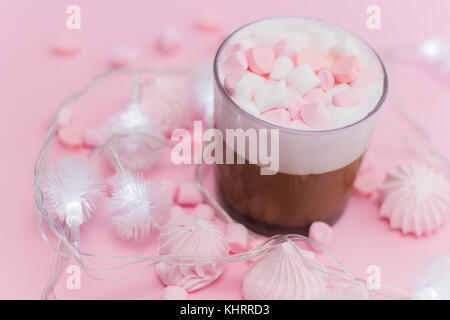 Heiße Schokolade mit Sahne, Marshmallows und herzförmige Pralinen auf Rosa pastell Hintergrund Stockfoto