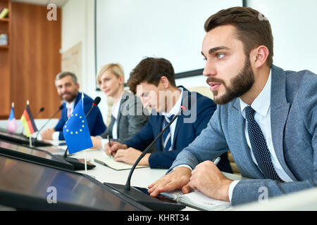 Portrait von mehreren Business Menschen die Teilnahme an der politischen Debatte während der Pressekonferenz die Beantwortung von Medienanfragen, bärtiger Mann sp in Reihe Stockfoto