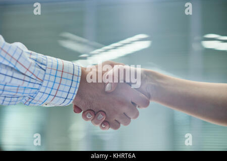 Nahaufnahme von zwei unkenntlich Geschäft Leute, Mann und Frau, Hände schütteln im Amt nach der erfolgreichen Deal Stockfoto
