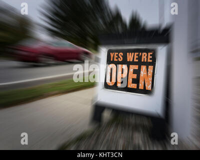 Zoomen Sie auf Ja Wir sind offen auf einem Bürgersteig in der Nähe der Straße platziert. Zeichen zu fördern, potenzielle Kunden im Store Shop entlang kleiner verteilt sind Stockfoto