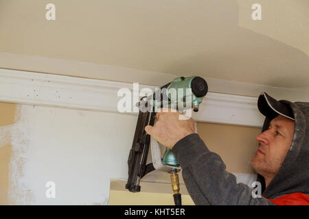 Tischler Brad mit Bolzenschußgeräten zu Stuckelemente, Verkleidung der Warnhinweis, dass alle Power Tools Stockfoto