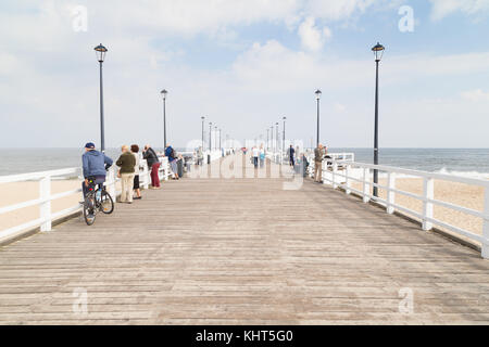 Einige Leute an der hölzernen brzezno Pier in Danzig, Polen, an einem sonnigen Tag im Herbst. Stockfoto