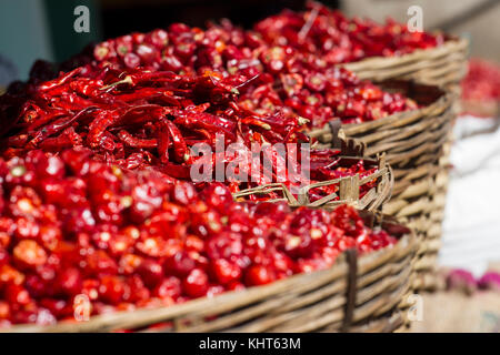Getrocknete Chilischoten Bambus Korb auf Holztisch, Nahaufnahme, getrockneten Chili im Warenkorb schließen bis rote getrocknete Chili, getrocknete rote Schüttelfrost Gewürze von Thailand. blur Bild Stockfoto