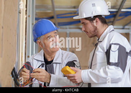 Bauherren mit einem gelben Multimeter Haus zu kalibrieren Stockfoto