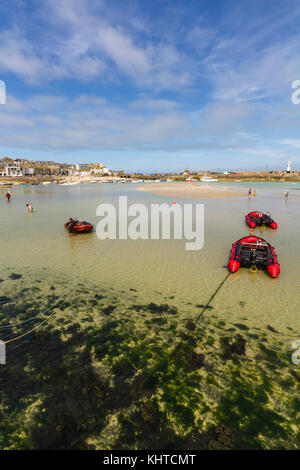 Blick auf die Bucht von St Ives bei Ebbe mit geerdetem Boote und Menschen Paddeln in das klare Wasser. Stockfoto