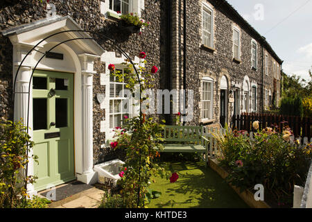 Großbritannien, England, Norfolk, Thetford, Castle Street, Terrasse von Feuerstein und Backstein gebauten Häuser, Sitzbank in kleinen Vorgarten Stockfoto