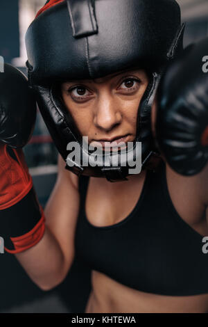 Nahaufnahme, Porträt eines weiblichen Boxer in ihren Boxen. Frau Boxer an einem Boxen studio tragen Kopfschutz und Boxhandschuhen. Stockfoto