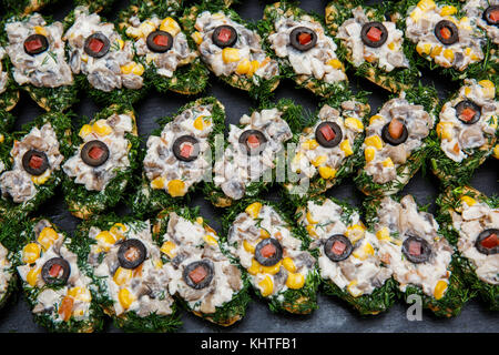 Auswahl an leckeren Bruschetta oder Häppchen auf geröstetem Baguette mit Pilzen, Mais, Fenchel, Oliven, Tomaten, Mayonnaise, Sauce. Restaurant, Buffet t Stockfoto