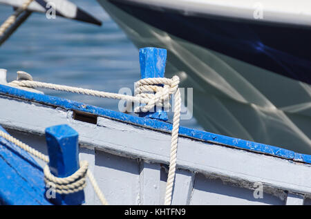 Blau Seil geknotet Festlegung über die Seite eines alten Holz Boot Stockfoto