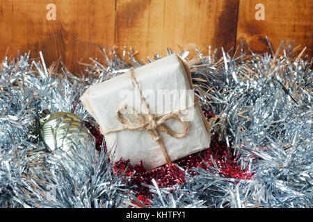Weihnachten Hintergrund mit Dekorationen und Geschenkboxen auf Holzbrett mit silbernem Lametta Stockfoto