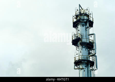 Der obere Teil eines gigantischen glänzende Metall Fraktionierung Säule bei einer chemischen oder Raffinerie mit einer Himmel Hintergrund Stockfoto