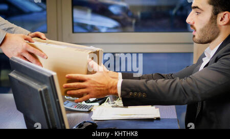 Geschäftsmann sitzt in seinem Büro und Paket ihn unkenntlich Kurier. Stockfoto
