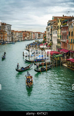 Blick von der Rialtobrücke auf Schiffe und Gondeln auf dem Canal Grande in Venedig an einem bewölkten Tag Stockfoto