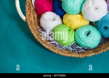 Bunte Garne Bälle in den Korb auf der Holz- Hintergrund. getönt. Stockfoto
