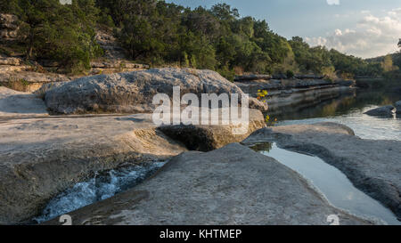 Wasser durch Felszeichnungen mit ruhigen Stream im Hintergrund fließt Stockfoto