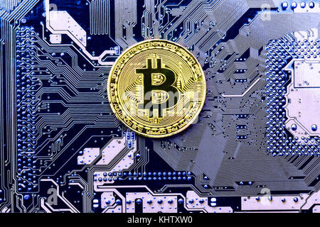 Goldmünze Bitcoin liegt auf dem Computer Board Stockfoto