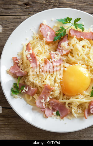 Spaghetti Carbonara Nudeln mit Ei, Speck und Parmesan - Hausgemachte gesunde italienische Pasta Carbonara auf hölzernen Hintergrund Stockfoto